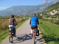 Ein Mann und eine Frau radeln auf dem Etschradweg durch die wunderschöne Südtiroler Bergwelt..