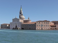 Ein venezianisches Wassertaxi passiert einen prächtigen, vom Campanile überragten Palazzo.