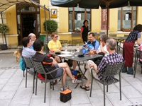 Eine Gruppe Radler sitzt an einem Tisch mit kühlen Getränken auf einer Terrasse eines Cafés