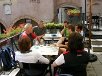 Eine Gruppe Radler sitzt an einem Tisch auf einer Terrasse eines Restaurants und trinkt kühle Getränke