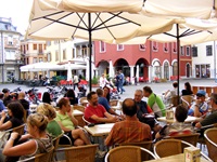 Gäste sitzen in einem Café in der Fußgängerzone in Cividale