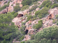 Zerklüftete rote Felsen mit Höhlen an der Südküste Sardiniens.