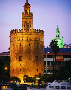Blick auf den in der Nacht beleuchteten Torre del Oro - einen militärischen Turm, der vom Rest der Stadtmauer getrennt ist, in Sevilla und gilt als eines der Wahrzeichen der Stadt