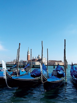 Auf dem Wasser schaukelnde Gondeln in Venedig; im Hintergrund der berühmte Campanile (= Glockenturm).