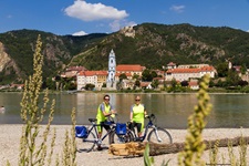 Zwei Radler posieren vor dem Stift Dürnstein für ein Foto.