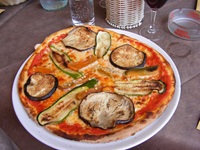 Eine leckere, mit Auberginen- und Zucchinischeiben belegte Pizza.