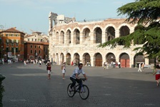 Fußgänger und Radfahrer tummeln sich vor dem weltberühmten Amphitheater von Verona.