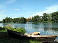 Ein Nachen liegt gegenüber der Wasserburg Trakai am Ufer des Sees.