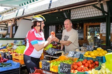 Eine Radlerin kauft ungarisches Paprikagewürz an einem Marktstand.