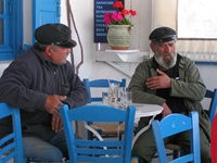 Einheimische auf den Kykladen sitzen in einem Café und unterhalten sich