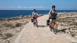 Zwei Radlerinnen auf einer Küstenstraße im Salento.