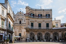 Die Piazza Immacolata in Martina Franca mit ihrem halbrunden Arkadengang. Im Hintergrund ist der Dom San Martino zu erkennen.