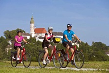 Drei Radler fahren einen Radweg auf der Strecke der Münchner Seenrunde entlang