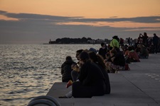 Eine Reisegruppe genießt die Abendstimmung über dem Hafen von Zadar.