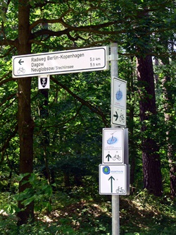 Ein Radweg-Schild des Berlin-Kopenhagen-Radwegs an einer Kreuzuung