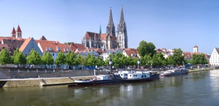 Blick über die Donau mit angelegten Schiffen bis zum Dom St. Peter mit seinen beiden Türmen in Regensburg