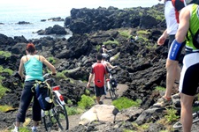 Eine Gruppe Radfahrer schiebt ihre Räder an der Flanke des Ätna entlang.