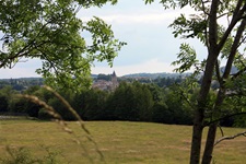 Schöner Ausblick auf ein hinter einer Baumreihe gelegenes Dorf mit Kirche im Südburgund.