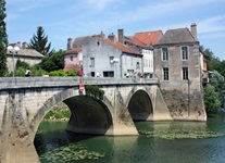 Radler überqueren eine Brücke in einem südburgundischen Dorf.