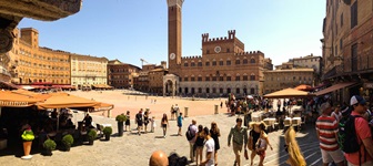 Touristen schlendern über die Piazza del Campo in Siena.