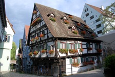 Ein Fachwerkhaus im Fischerviertel von Ulm, das an den Fenstern mit Blumen geschmückt ist