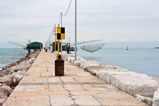 Ein steinerner Pier in einem italienischen Hafen.