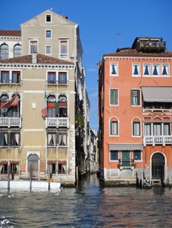 Bunte Häuser flankieren einen engen Kanal in Venedig.