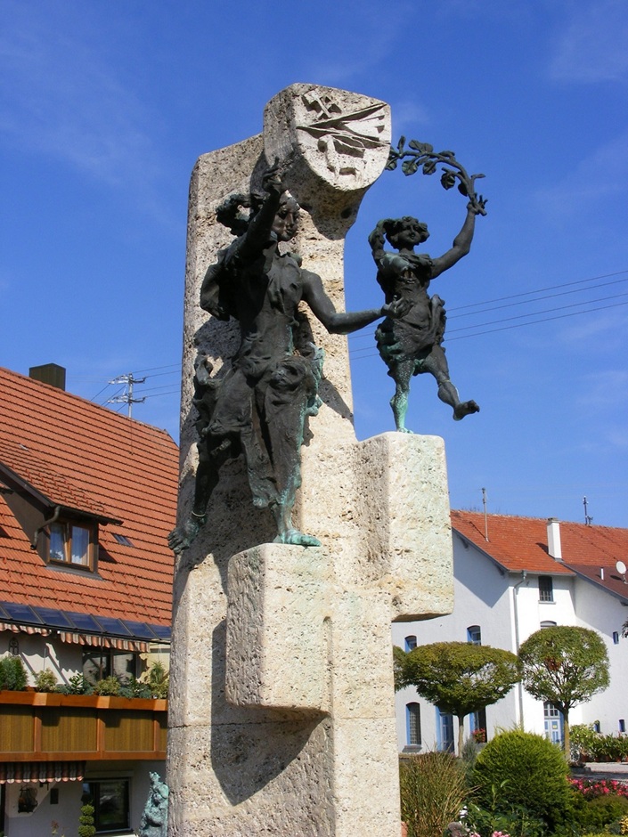 Der Donau-Lauchert-Brunnen mit zwei steinernen Figuren und einem Wappen an der Spitze
