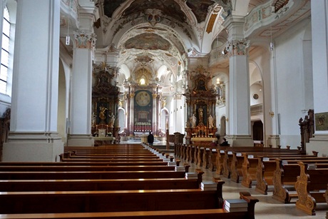 Innenraum der Klosterkirche mit Holzbänken und den barocken Verzierungen