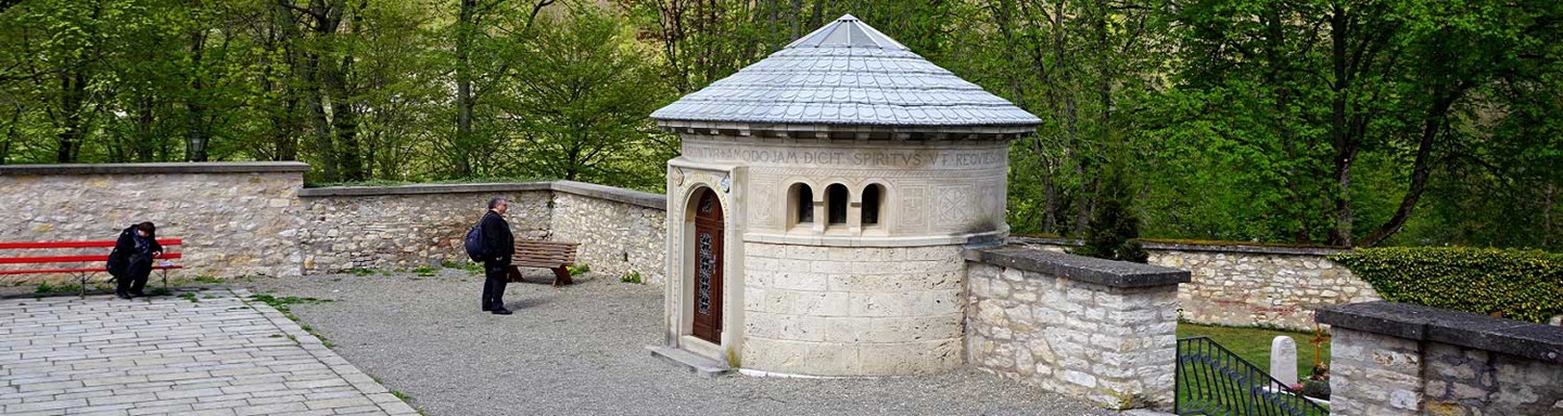 Innenhof mit Rondell der Klosterkirche Beuron, in dem zwei Menschen, einer davon sitzt auf einer roten Bank