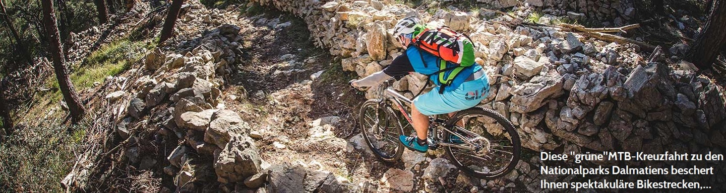 Ein Mountainbiker mit Helm fährt einen steinigen Trail im Nationalpark von Dalmatien, Kroatien, hinab