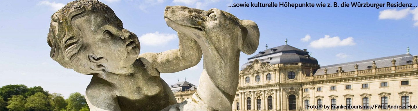 Im Vordergrund Skulptur eines Kindes, das einen Hund streichelt, dahinter die Würzburger Residenz