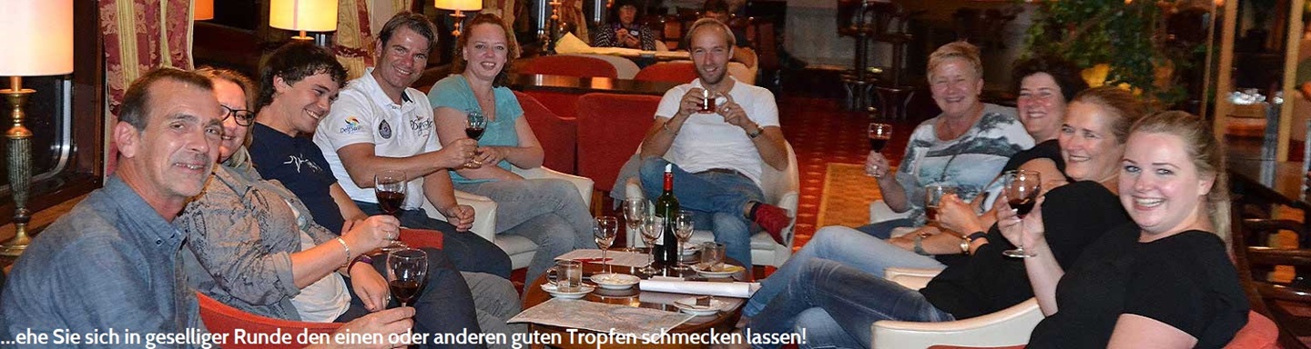 Eine Menschengruppe genießt an Bord ihre Pause mit gefüllten Weingläsern