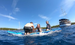 Eine Familie in einem Schlauchboot hat sichtlich Spaß auf dem Meer. Am rechten Bildrand ist die San Snova zu erkennen.