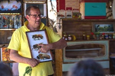 Imker Goran erklärt anhand eines Bildes, wie man die Bienenkönigin, die Arbeiterinnen und die Bienenmännchen erkennen kann.