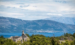 Die Ruine eines verlassenen Hauses auf der Insel Hvarb bildet zusammen mit dem Meer und der dahinter aufragenden Bergkette ein reizvolles Fotomotiv.