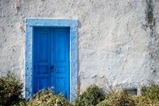 Ein weißes Haus mit blauer Eingangstüre auf den Kykladen.