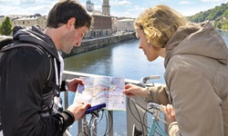 Ein Radlerpärchen steht in Passau auf einer Brücke und studiert den Stadtplan.