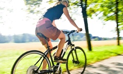 Eine Radlerin macht auf einem asphaltierten Radweg im Salzburger Land ordentlich Strecke.