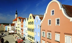 Die bunten Häuserfassaden rund um den Oberen Stadtplatz von Schärding, im Hintergrund die Stadtpfarrkirche St. Georg.