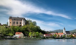 Schloss Greinburg thront über dem Donauufer; am rechten Bildrand ist die Pfarrkirche von Grein zu sehen.