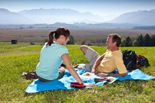 Ein junges Paar genießt ein Picknick bei Murnau.