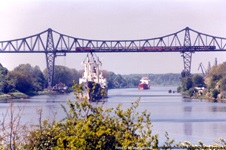 Zwei Schiffe auf dem Nord-Ostsee-Kanal fahren unter der Rendsburger Eisenbahnhochbrücke durch