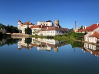 Blick über den Fluss Nežárka auf das imposante Schloss Neuhaus in Tschechien