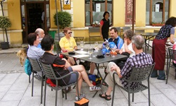Eine Gruppe Radler sitzt an einem Tisch mit kühlen Getränken auf einer Terrasse eines Cafés