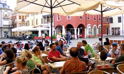 Gäste sitzen in einem Café in der Fußgängerzone in Cividale