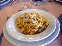 Ein Hauptspeisenteller mit Tagliatelle, Gemüse und geriebenen Parmesan