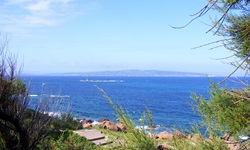 Wunderschöner Blick auf das tiefblaue Meer vor der Südküste Sardiniens und eine kleine Insel mit Leuchtturm.