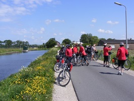 Eine Radlergruppe macht eine Pause und auf einem Radweg am Ijsselmeer