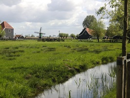 Blick auf ein uriges Dorf mit einer kleinen Windmühle in Holland beim Ijsselmeer